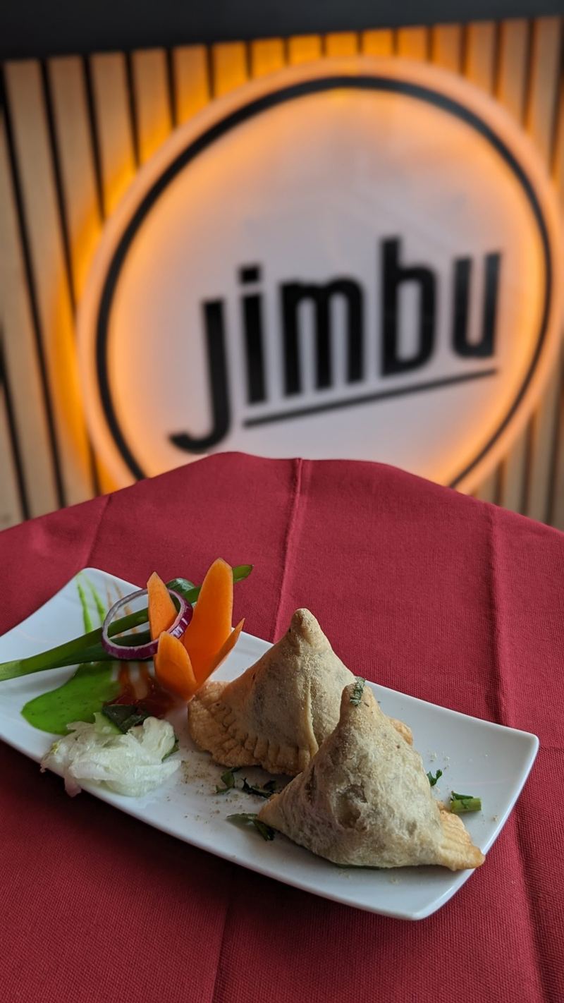 Samosas croustillants devant l'enseigne du restaurant Jimbu à Montévrain